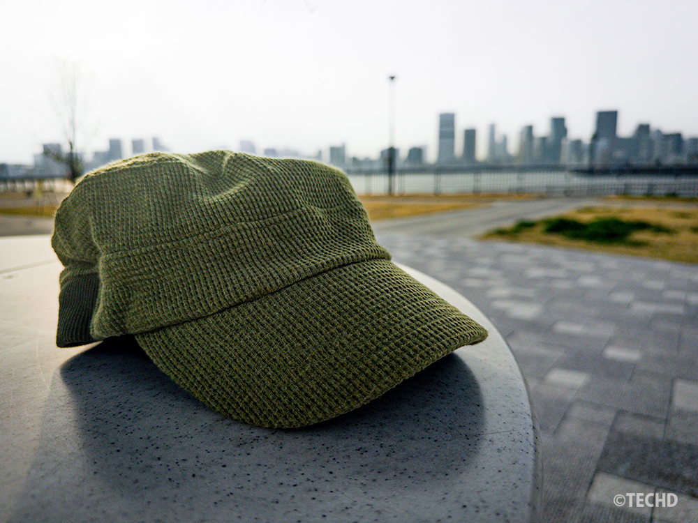 補正後の画像：LightroomモバイルのAIマスクと自動補正を適用。主役の帽子が際立ち、背景の空やビル群も明るく鮮やかに仕上がった劇的補正の作例。