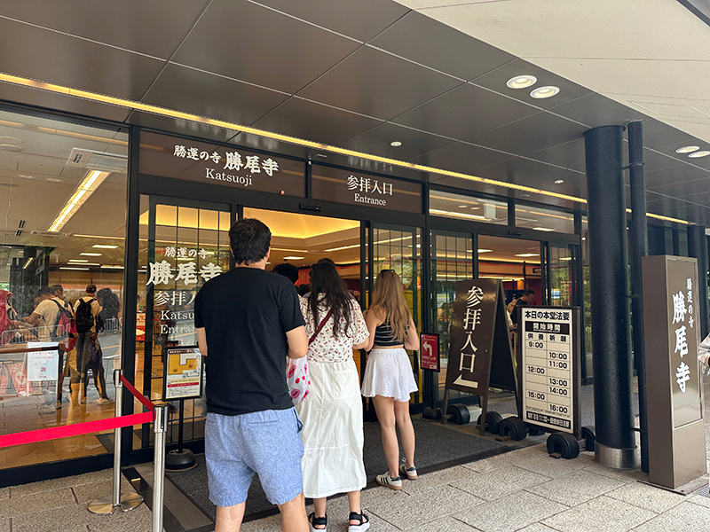 勝尾寺の参拝入口の写真。外国人観光客が並んでいる様子。