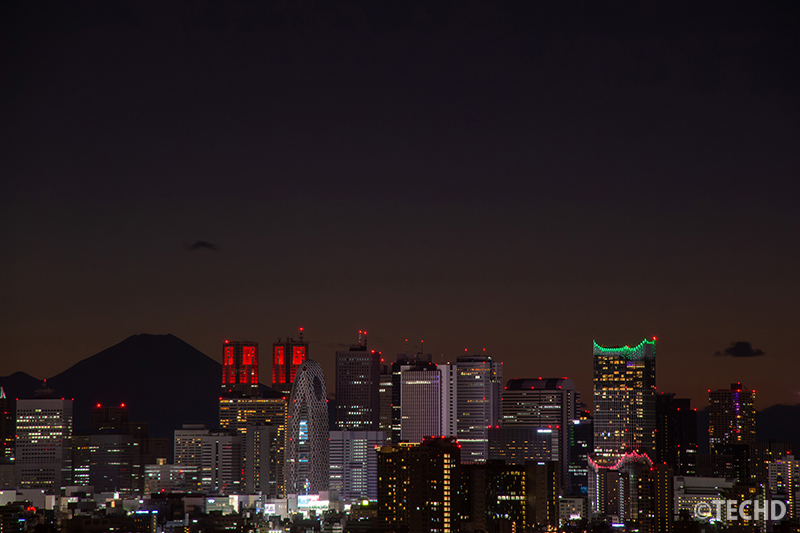 冬の夜、文京シビックセンター展望ラウンジから望む新宿高層ビル群と富士山のシルエットの夜景写真