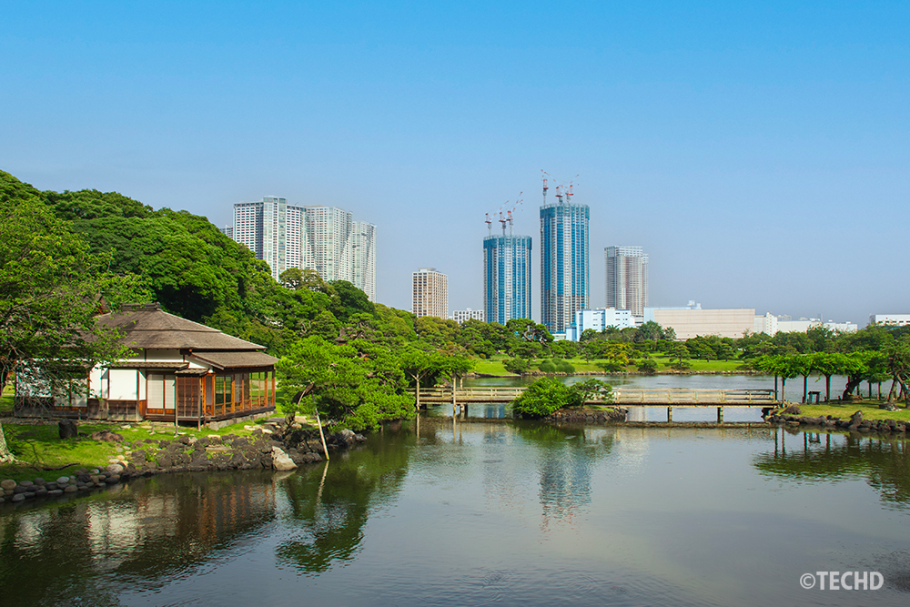 青空に編集された浜離宮恩賜庭園の風景写真。AI編集で明るく仕上げ、ストックフォト審査を通過したリメイク版。