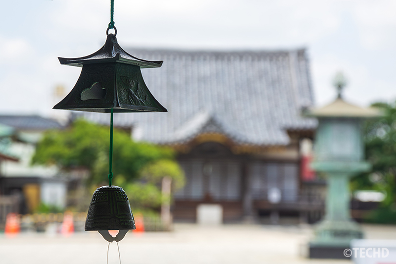富山県・高岡の青銅風鈴を背景ぼかしで撮影。落ち着いた和の印象を強調。