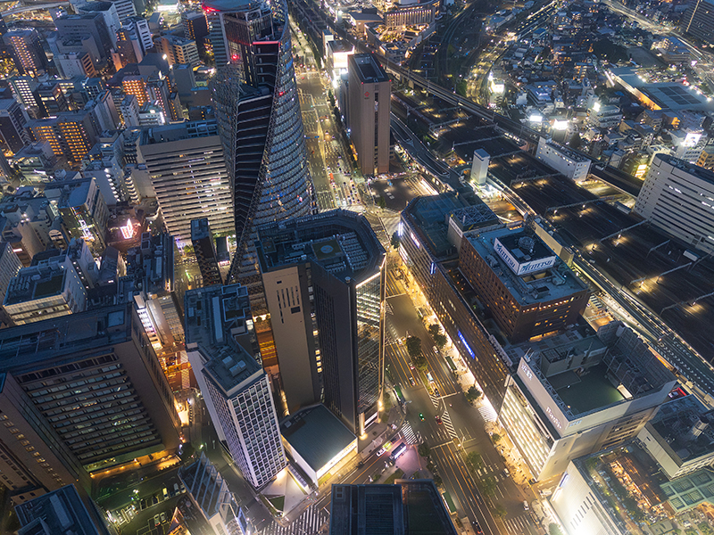 スカイプロムナードから見下ろした名古屋駅南側の夜景。ビル群と交差点がライトアップされ、日没後の空に溶け込むような光景。