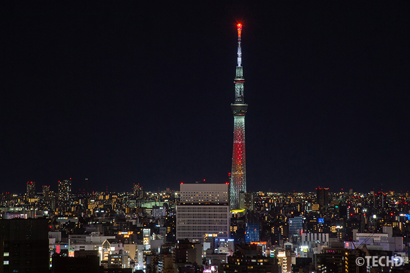 文京シビックセンター展望ラウンジから撮影した、夜にライトアップされた東京スカイツリーと周囲の街並み