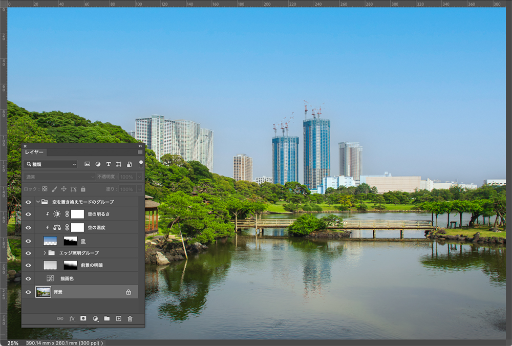 Photoshopで「空を置き換え」機能を使用し、都市と庭園の風景写真の背景を青空に差し替えた編集画面。レイヤーパネルには空や効果が個別のレイヤーとして表示されている。