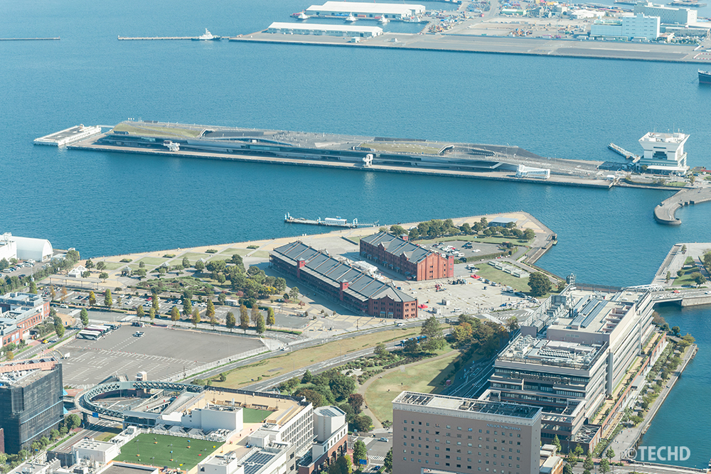 スカイガーデンから見下ろす赤レンガ倉庫と大さん橋。横浜港の歴史的建造物と近代的な港湾施設が並ぶ昼間の風景。