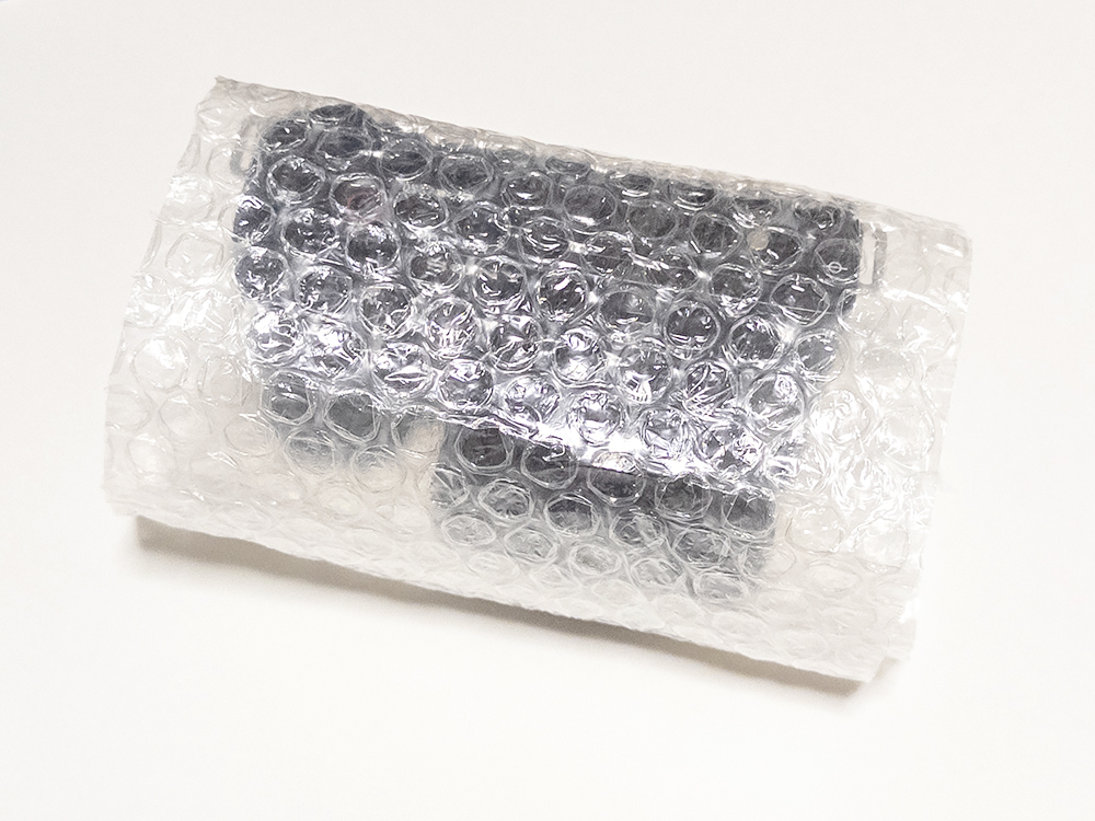 ゲオあれこれレンタルで届いたカメラ本体が、プチプチの緩衝材で丁寧に包まれている様子