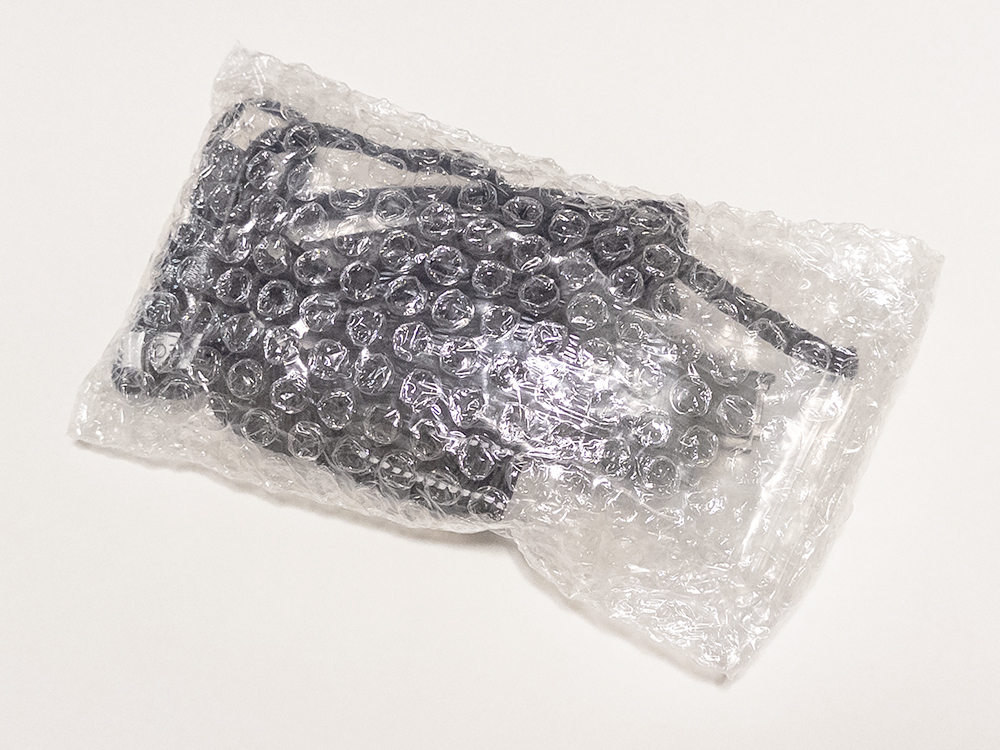 USBケーブル・ストラップ・バッテリーなど、レンタル付属品一式がプチプチの緩衝材でまとめて保護されている様子。