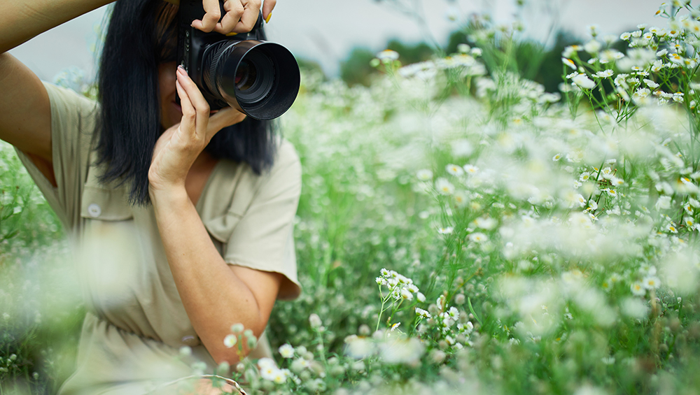 一眼レフで自然風景を撮影する初心者クリエイターの様子。今週末からストックフォト撮影を始めるイメージ