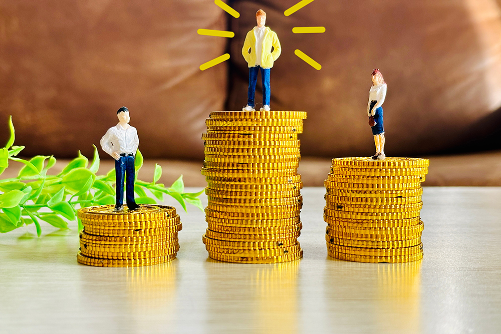 各３つのコインの上には人形がそれぞれ置かれている。真ん中のコインが一番高く、乗っている人形が強調されている。収益をイメージする画像である。