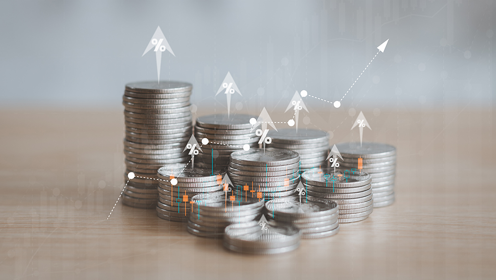 不労所得や資産形成の積み上げを象徴する、高く積まれたコインと右肩上がりの成長グラフの合成写真