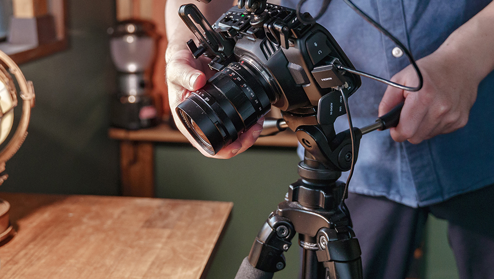 三脚に固定されたカメラを調整する撮影者の手元。スローシャッター撮影に欠かせない、安定したカメラセッティングの様子
